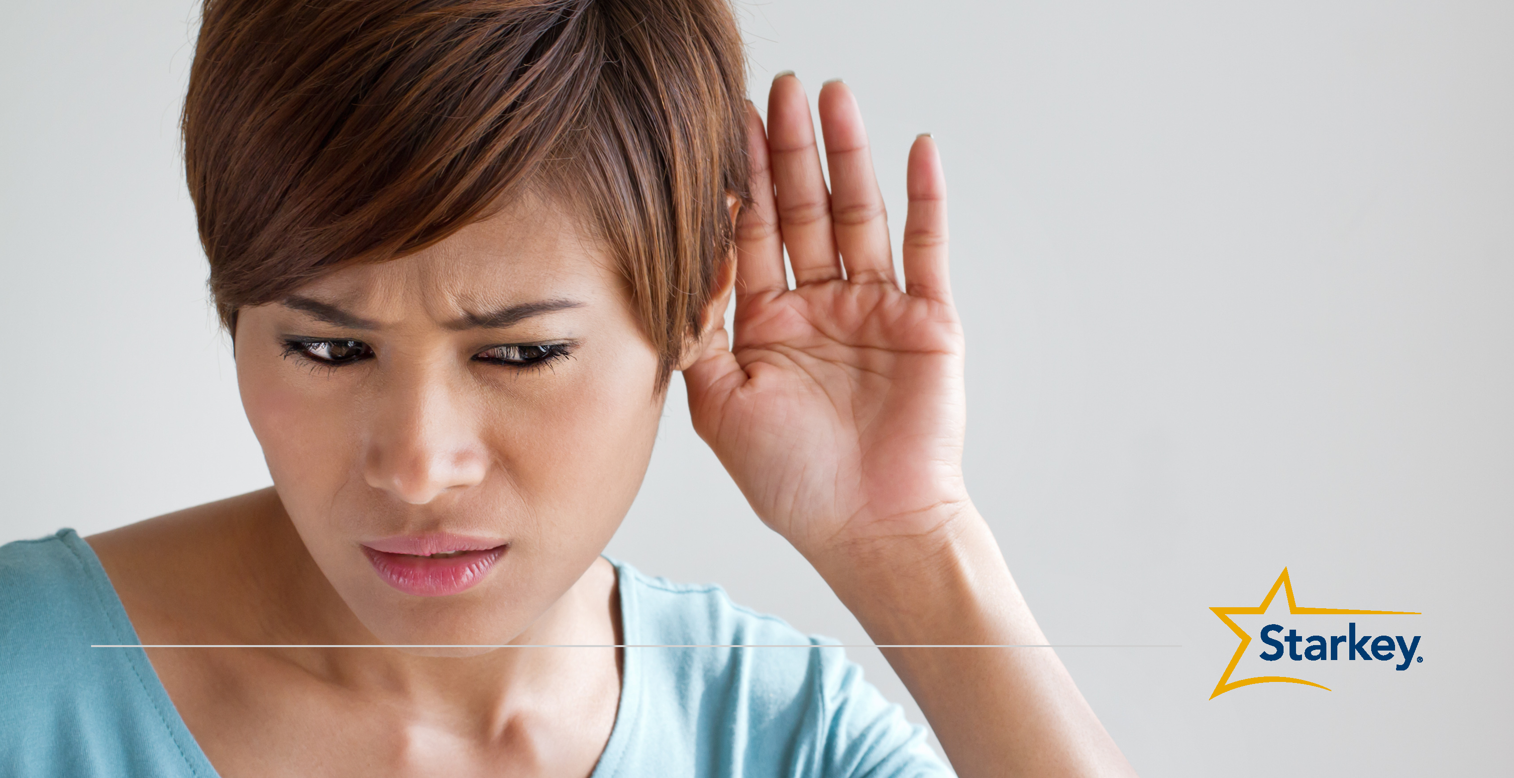 Woman holding her left palm behind her left ear